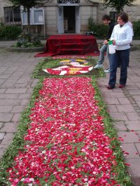 Die Ministranten richten den Blumenteppich vor dem Pfarrzentrum